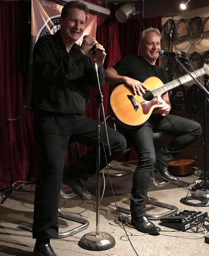 Dave sharing a laugh with country artist Thomas Wade on stage at The Moonshine Cafe